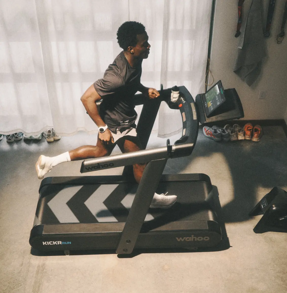 Runner training on a Wahoo KICKR RUN smart treadmill in a home setup
